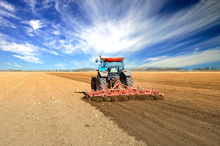 A farmer on a tractor prepares the land for the next growing season. Photo courtesy of Adobe Stock.