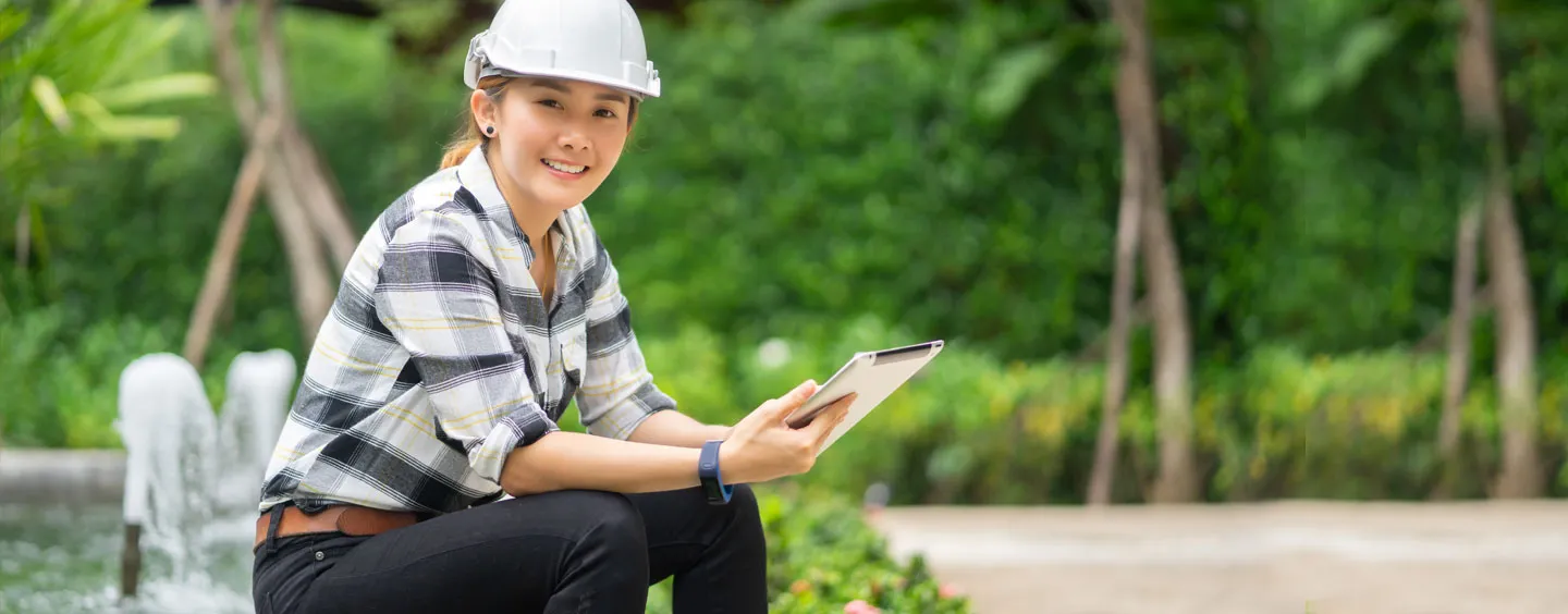 Woman wearing hardhat working on tablet, courtesy of Adobe Stock
