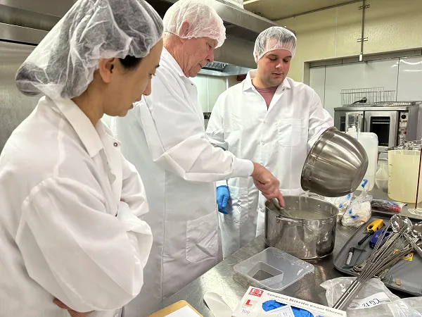From Left to Right: Xue Zhang, Chef Louis Chatham, and Dylan Lesak work on methods to control mites on dry-cured ham. Credit: Mississippi State University. 