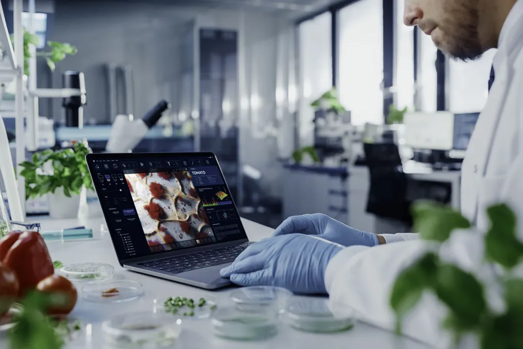 Image of scientist looking at laptop in lab courtesy of AdobeStock