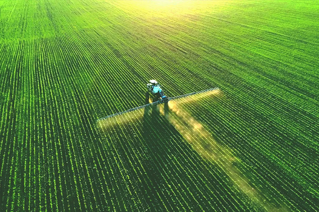 Aerial view of tractor spraying crop field. Image courtesy of Adobe Stock. 