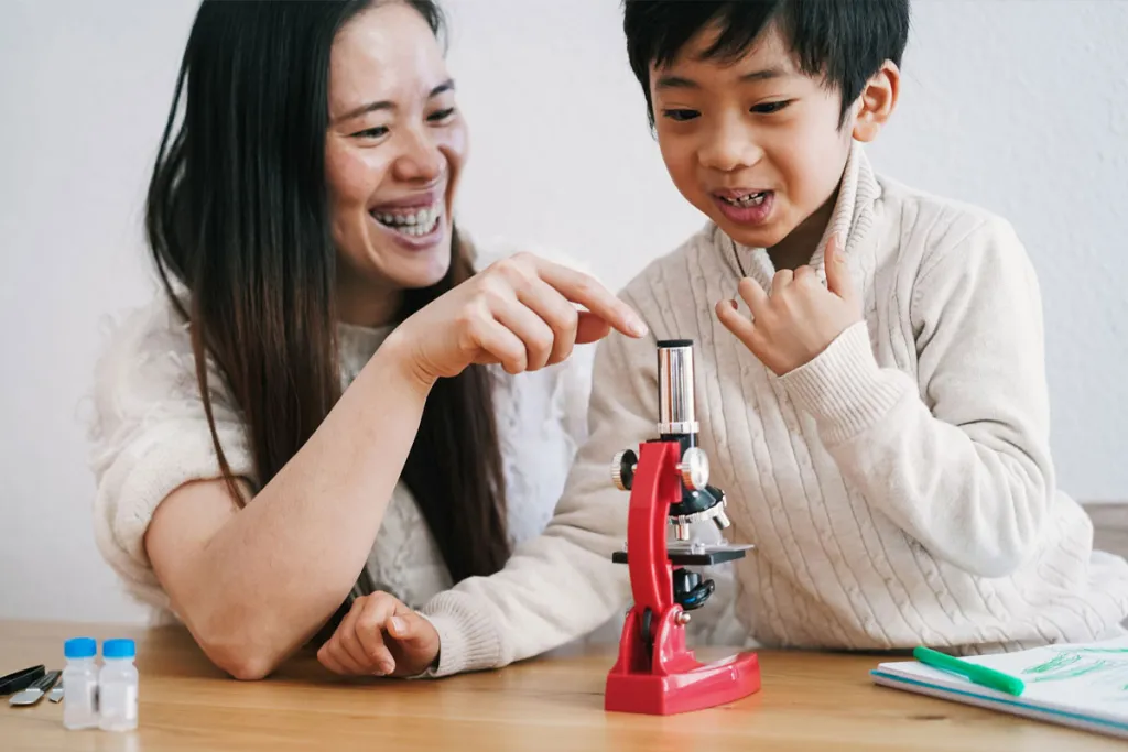 Image of mother and child looking at microscope, courtesy of Adobe Stock