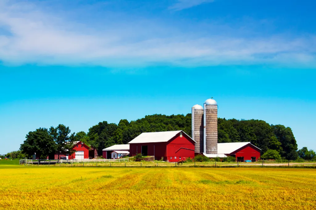 Farm scene with red barns and silos. Image courtesy of Adobe Stock. 