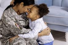 Woman wearing military uniform with child, courtesy of Adobe Stock