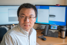 Dr. Li Ma working with computers and big data generated from the dairy industry. Image provided by Dr. Ma. 