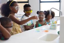 Elementary school students performing scientific experiment. Image courtesy of Adobe Stock. 