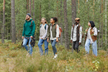 A group of people hiking through a forest. Image courtesy of Adobe Stock